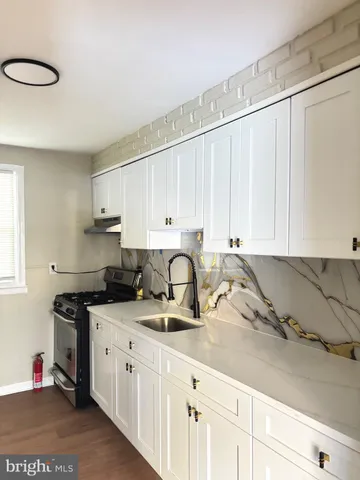 a kitchen with stainless steel appliances granite countertop a sink a stove and cabinets