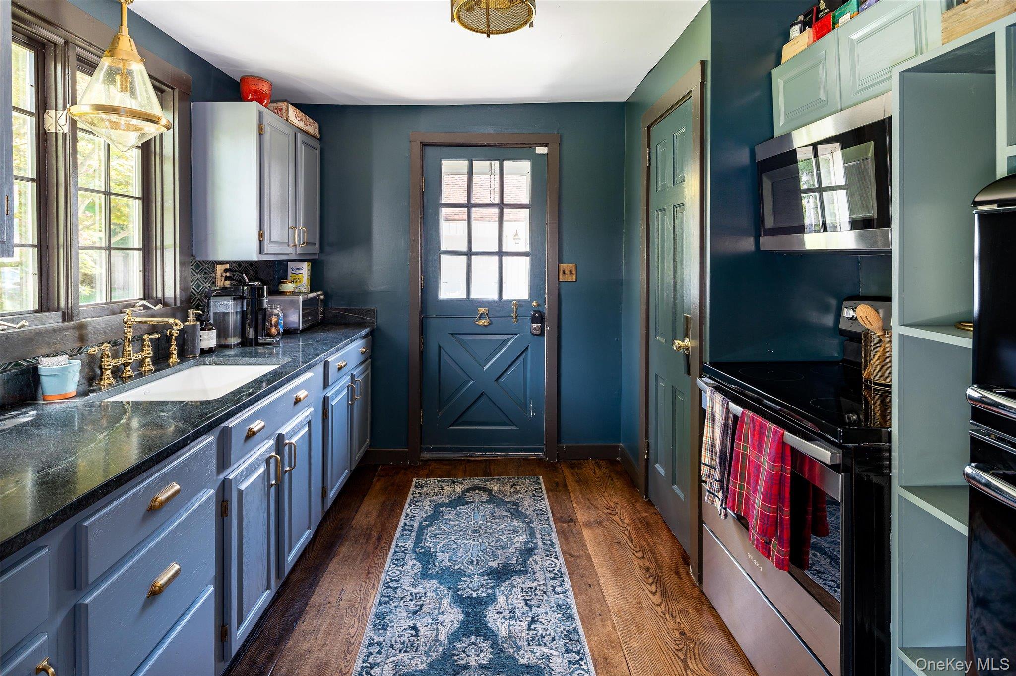 459 Old Post Road Bedford, NY 10506 - Photo 6 of 23 Kitchen featuring appliances with stainless steel finishes, dark wood-style flooring, blue cabinets, hanging light fixtures, and dark stone countertops
