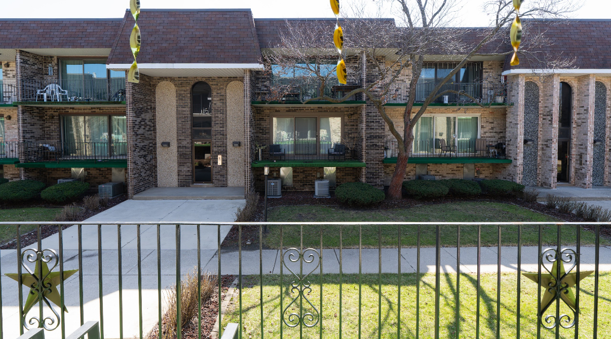 9140 South Pulaski Road, Unit 1W Oak Lawn, IL 60453 - Photo 14 of 17 a view of a brick house with a small yard and plants