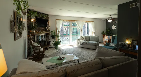 a living room with furniture a flat screen tv and a floor to ceiling window