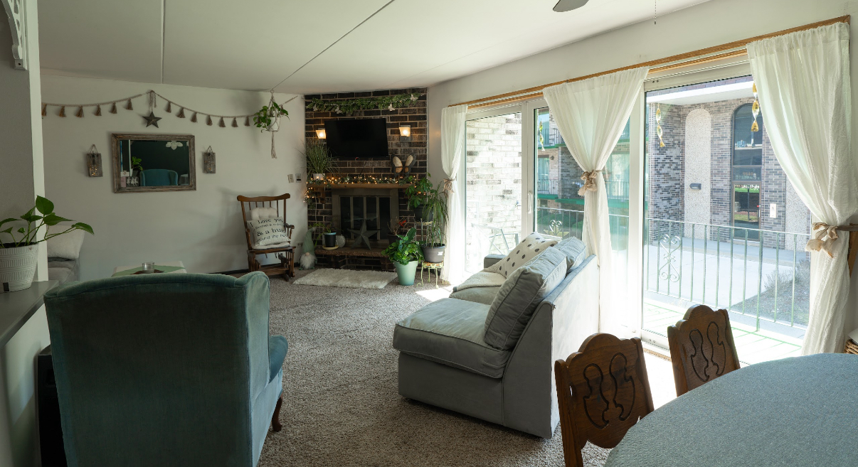 9140 South Pulaski Road, Unit 1W Oak Lawn, IL 60453 - Photo 7 of 17 a living room with furniture a flat screen tv and floor to ceiling window