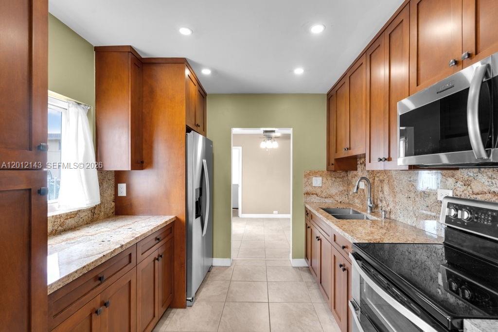 5651 Northwest 3rd Street Miami, FL 33126 - Photo 7 of 21 a kitchen with stainless steel appliances granite countertop a stove a sink and a refrigerator