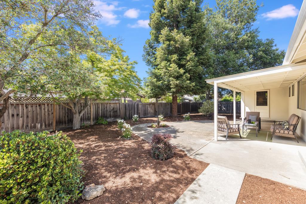 16239 Jacaranda Way Los Gatos, CA 95032 - Photo 19 of 20 a view of a backyard with table and chairs and a large tree