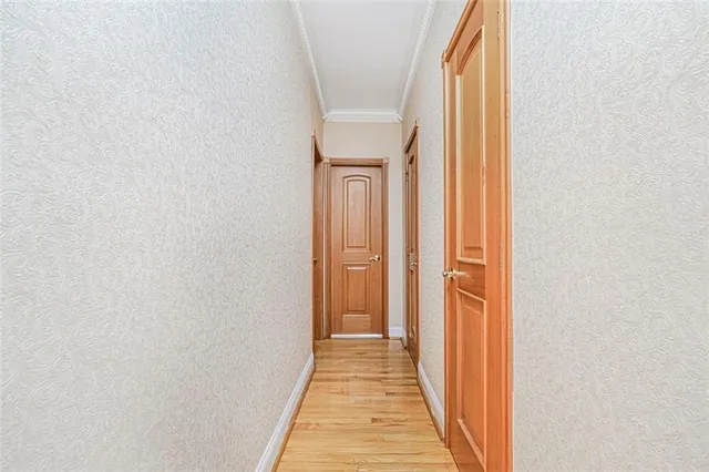 a view of a hallway with wooden floor and closet