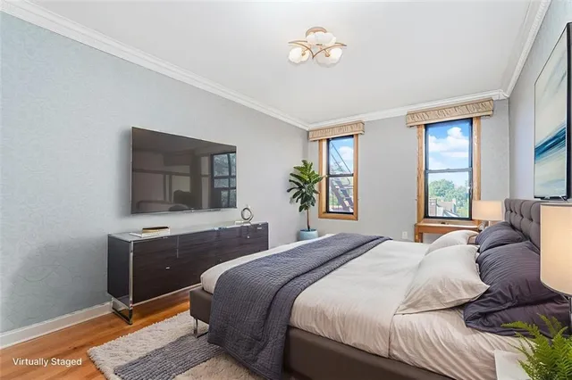a bedroom with a large bed and a flat tv screen on dresser