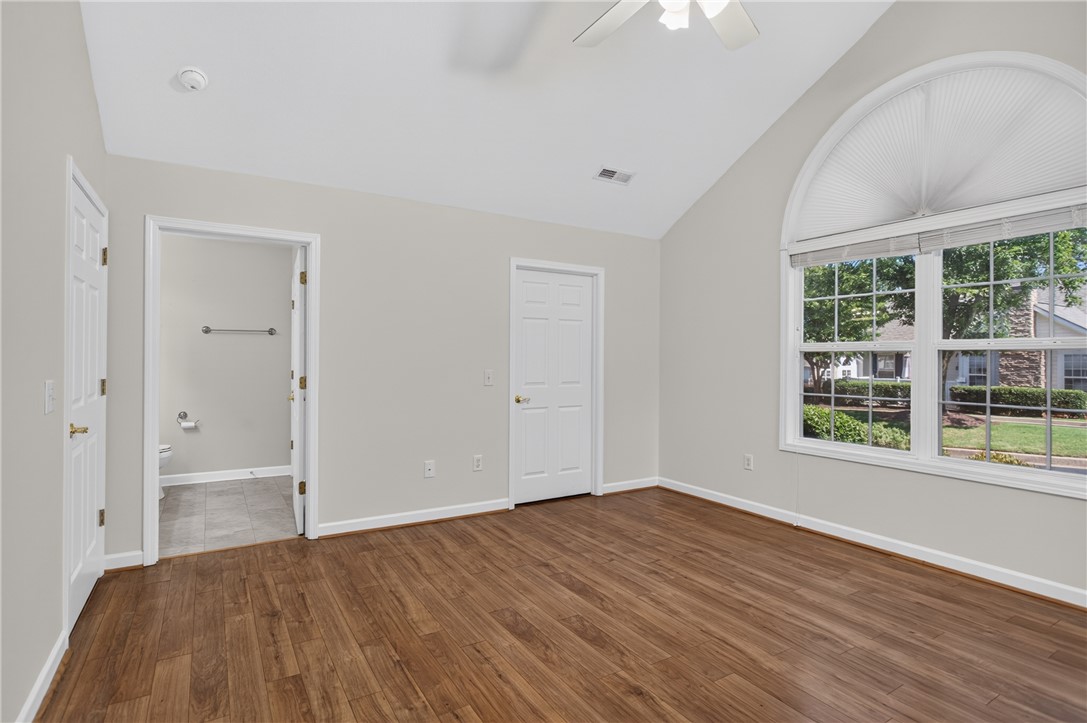 134 Life Style Lane Anderson, SC 29621 - Photo 14 of 44 A well-lit bedroom features vaulted ceilings, hardwood flooring, and an arched window overlooking the neighborhood.