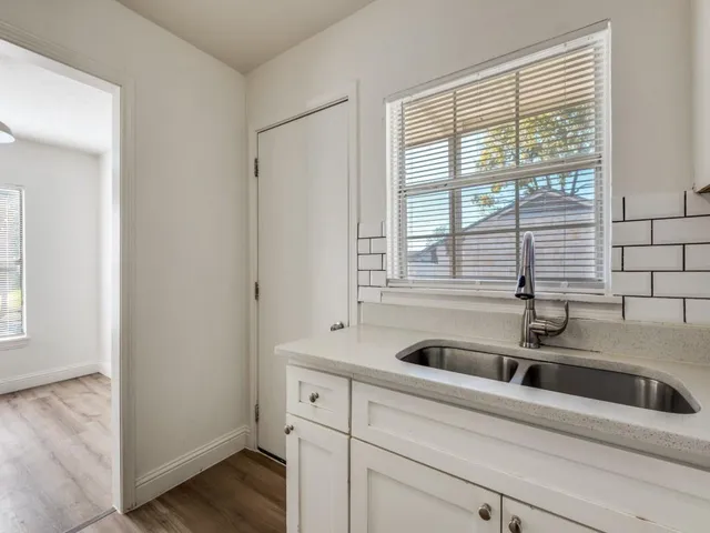a kitchen with white cabinets and white appliances