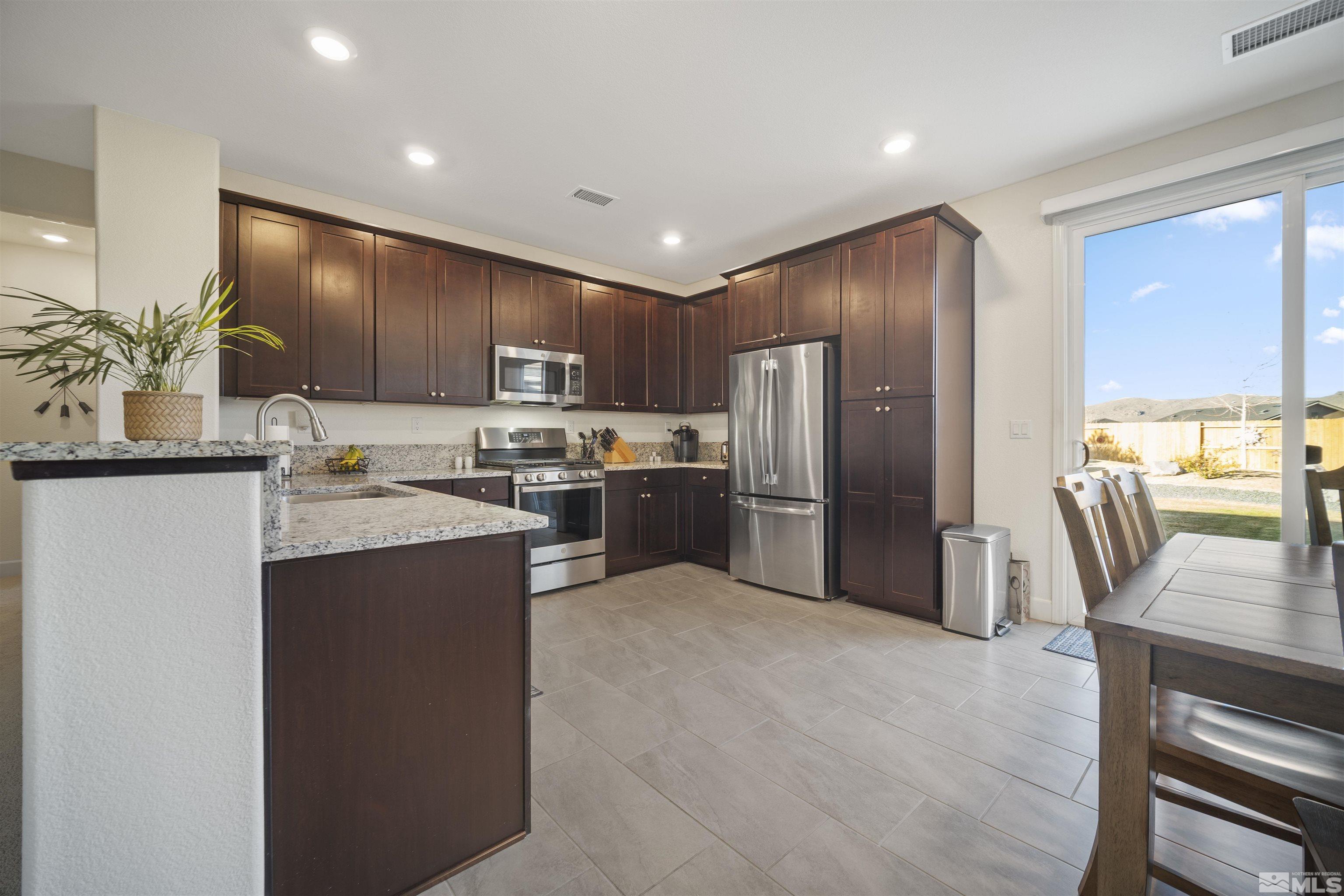 6713 Eagle Peak Drive Carson City, NV 89701 - Photo 11 of 40 a kitchen with stainless steel appliances granite countertop a refrigerator a stove top oven a sink and dishwasher