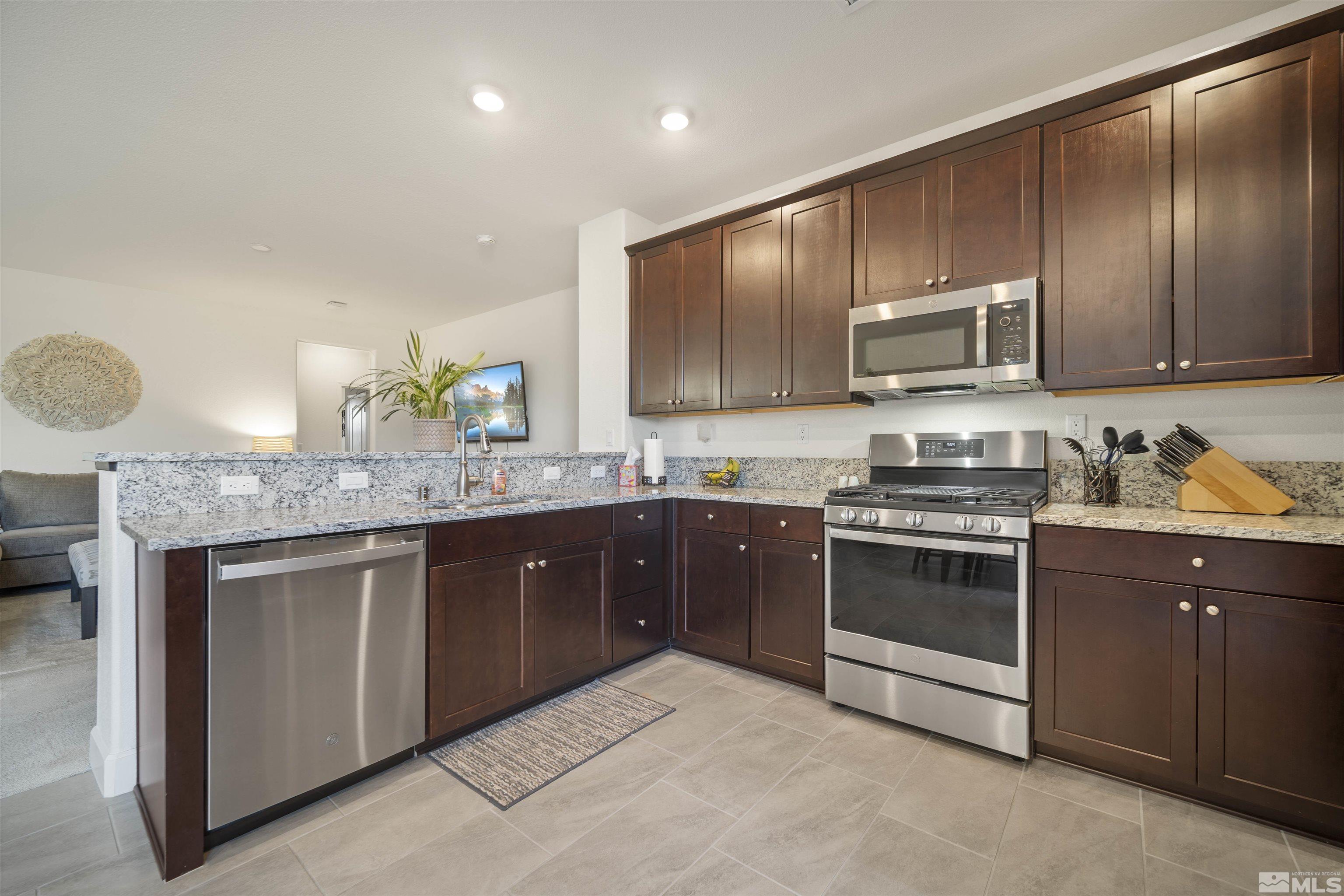 6713 Eagle Peak Drive Carson City, NV 89701 - Photo 12 of 40 a kitchen with stainless steel appliances granite countertop a stove a sink and a microwave