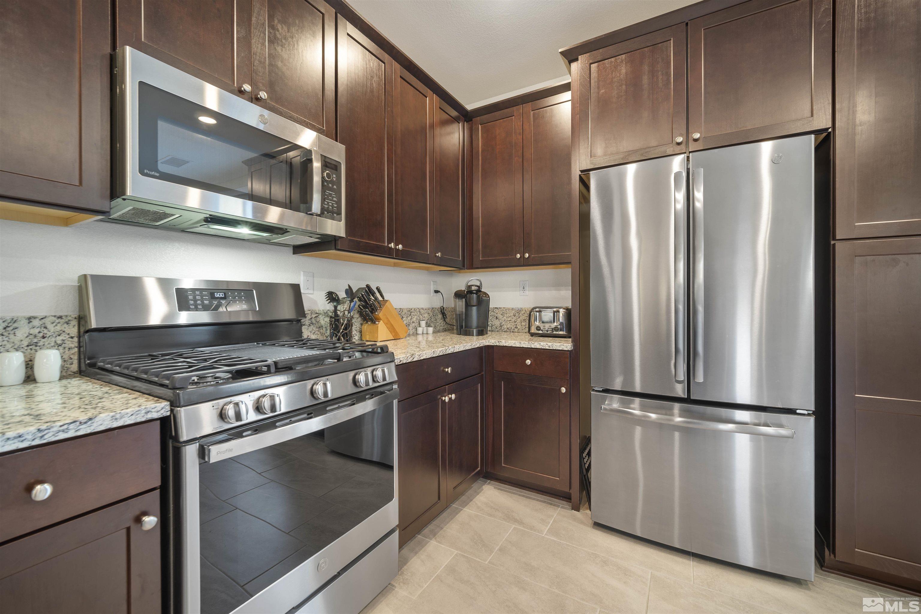 6713 Eagle Peak Drive Carson City, NV 89701 - Photo 14 of 40 a kitchen with stainless steel appliances granite countertop a refrigerator stove and microwave