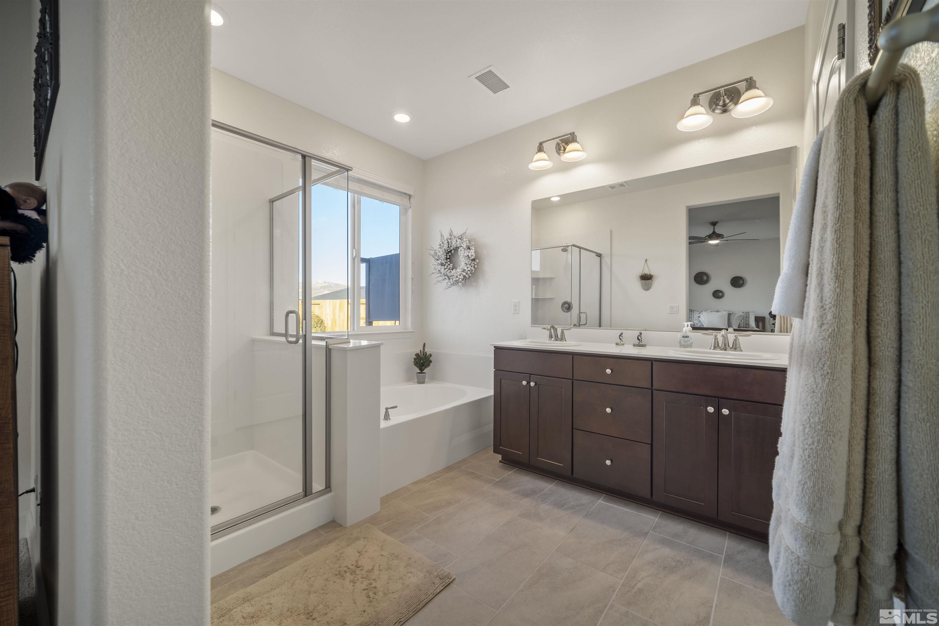 6713 Eagle Peak Drive Carson City, NV 89701 - Photo 21 of 40 a spacious bathroom with a double vanity sink a mirror and a shower