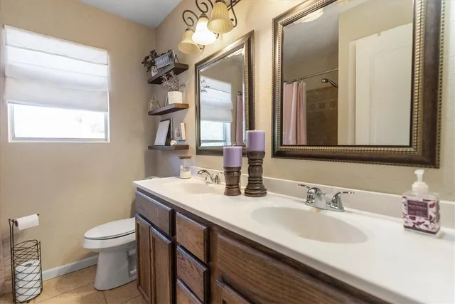 a bathroom with a granite countertop sink a mirror and shower