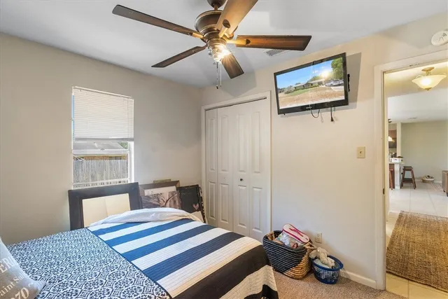 a bedroom with a bed a dresser and book shelfs