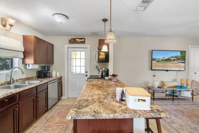 a kitchen with kitchen island a counter top space appliances and cabinets