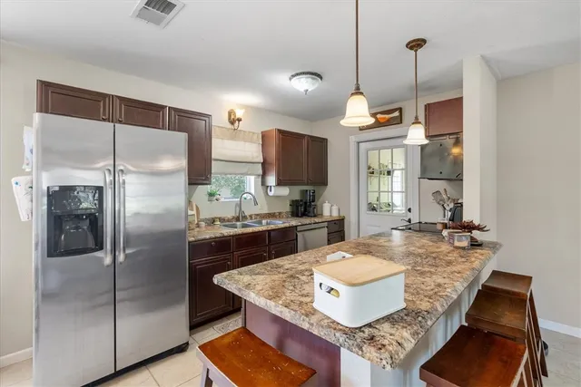 a kitchen with kitchen island a large window and chairs