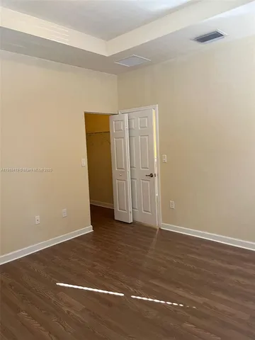 an empty room with wooden floor and closet