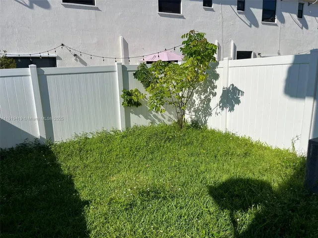 an aerial view of residential house with outdoor space and trees all around