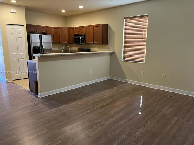 a kitchen with stainless steel appliances a sink cabinets and wooden floor
