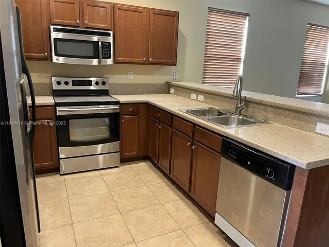 a kitchen with a sink stove and microwave