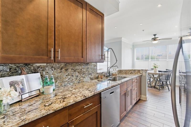 200 Renaissance Parkway Northeast, Unit 304 Atlanta, GA 30308 - Photo 12 of 40 a kitchen with granite countertop a sink a stove and cabinets
