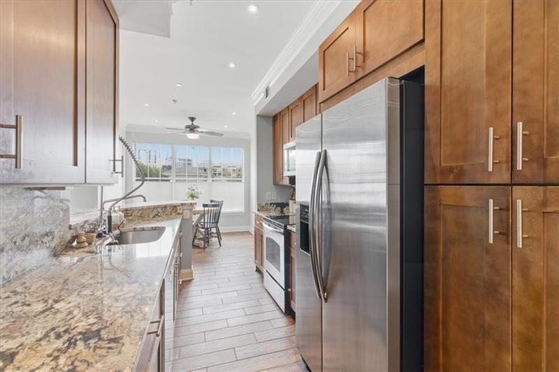 200 Renaissance Parkway Northeast, Unit 304 Atlanta, GA 30308 - Photo 13 of 40 a kitchen with stainless steel appliances granite countertop a refrigerator a stove and a sink with granite countertops