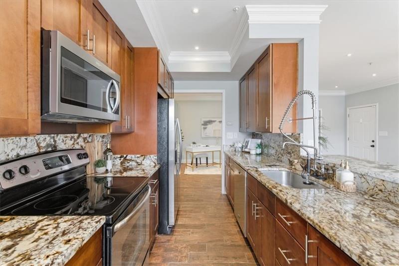 200 Renaissance Parkway Northeast, Unit 304 Atlanta, GA 30308 - Photo 8 of 40 a kitchen with stainless steel appliances granite countertop a stove and a sink