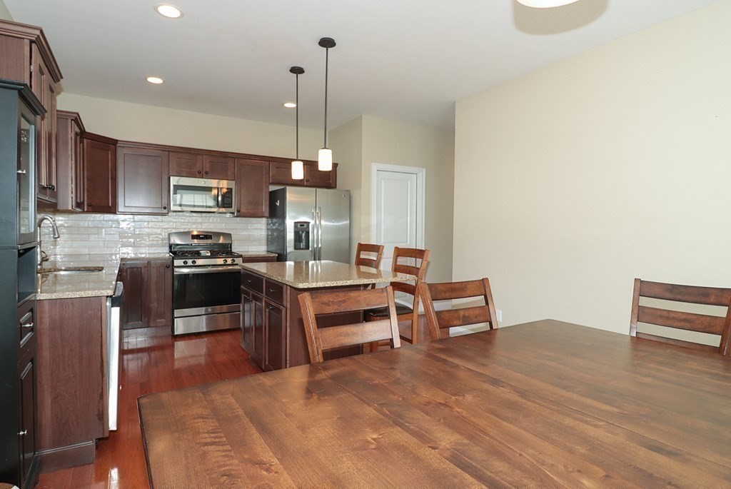 25 Eagle Nest Road, Unit 25 Clinton, MA 01510 - Photo 7 of 38 a kitchen with stainless steel appliances kitchen island granite countertop a stove a sink and a refrigerator