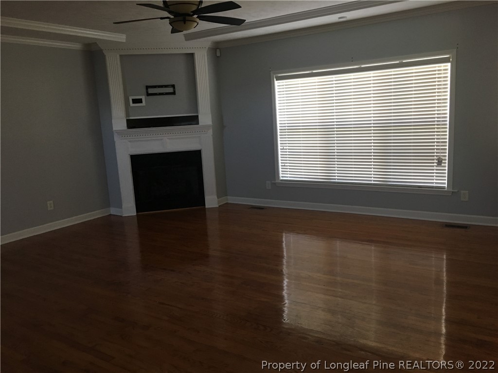 1409 Blue Ribbon Lane Hope Mills, NC 28348 - Photo 3 of 19 a view of a livingroom with a fireplace a ceiling fan and wooden floor