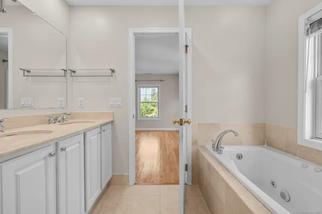 a bathroom with a bathtub a sink a vanity and a window