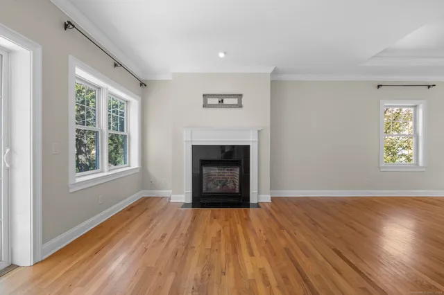 an empty room with windows and fireplace