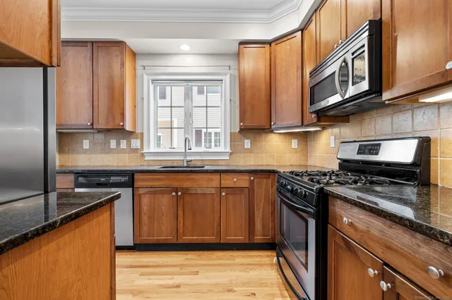 a kitchen with stainless steel appliances granite countertop a stove a sink dishwasher and a refrigerator