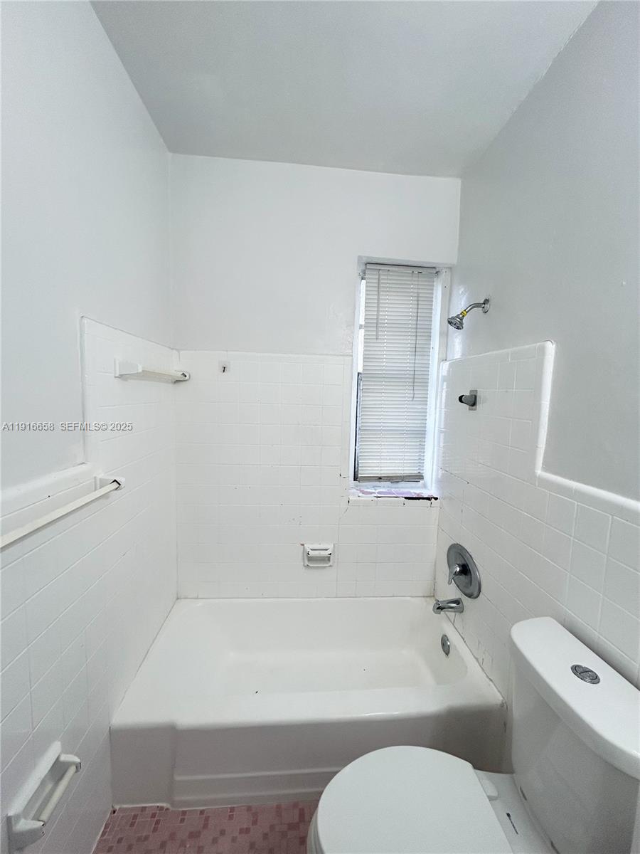 667 Northeast 86th Street, Unit 3B Miami, FL 33138 - Photo 6 of 6 a bathroom with a toilet and a bath tub