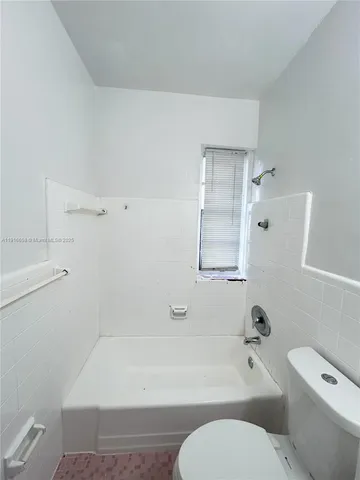 a bathroom with a toilet and a bath tub