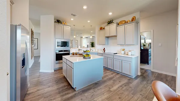 a kitchen with cabinets and wooden floor
