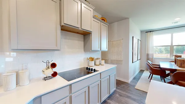 a kitchen with stainless steel appliances a sink a stove a window cabinets and a dining table
