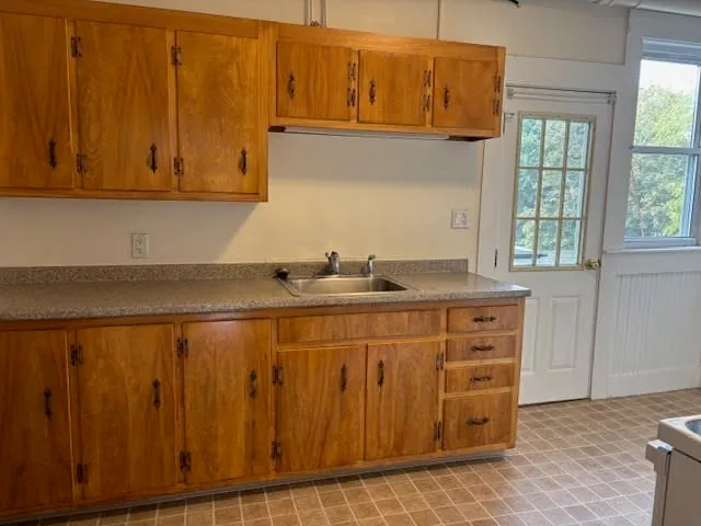 a kitchen with granite countertop white cabinets and sink