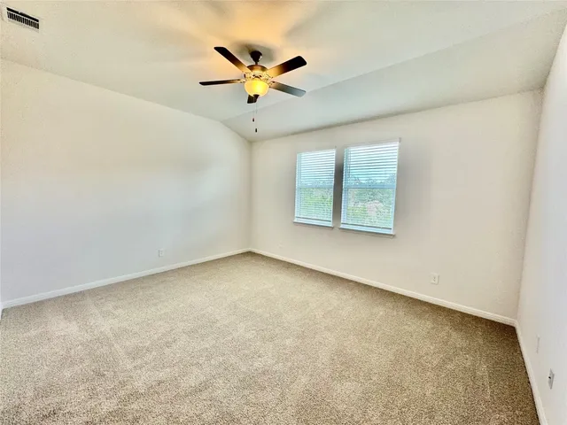 an empty room with a window and a fan