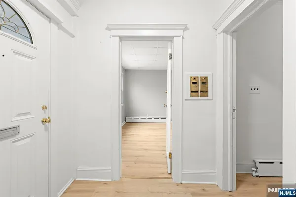 a view of a hallway with wooden floor and closet