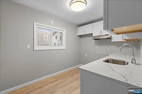 a kitchen with a sink cabinets and a wooden floor