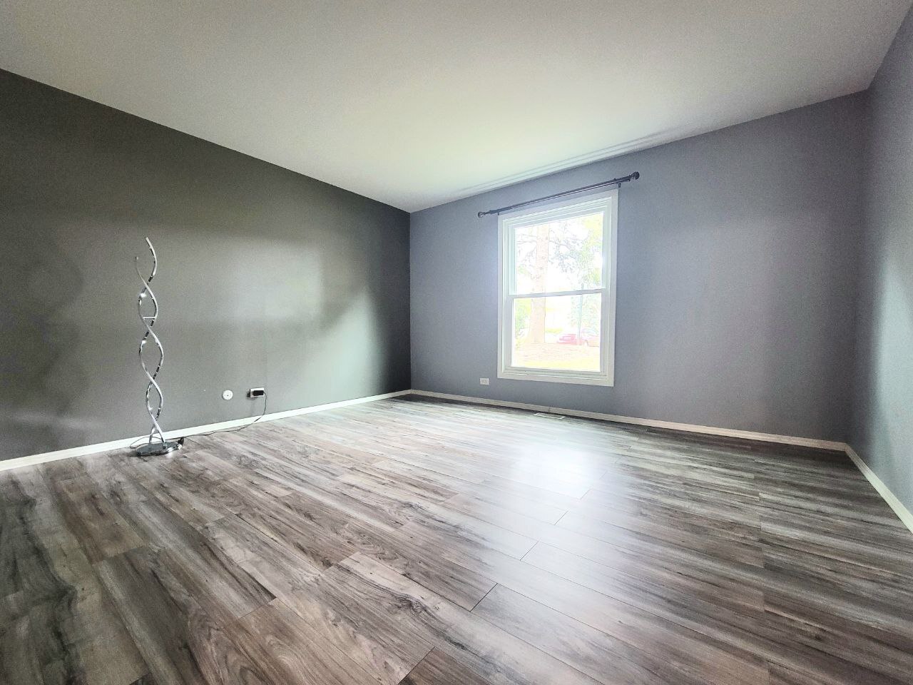 4730 Calvert Drive, Unit B1 Rolling Meadows, IL 60008 - Photo 15 of 23 a view of an empty room with wooden floor and window