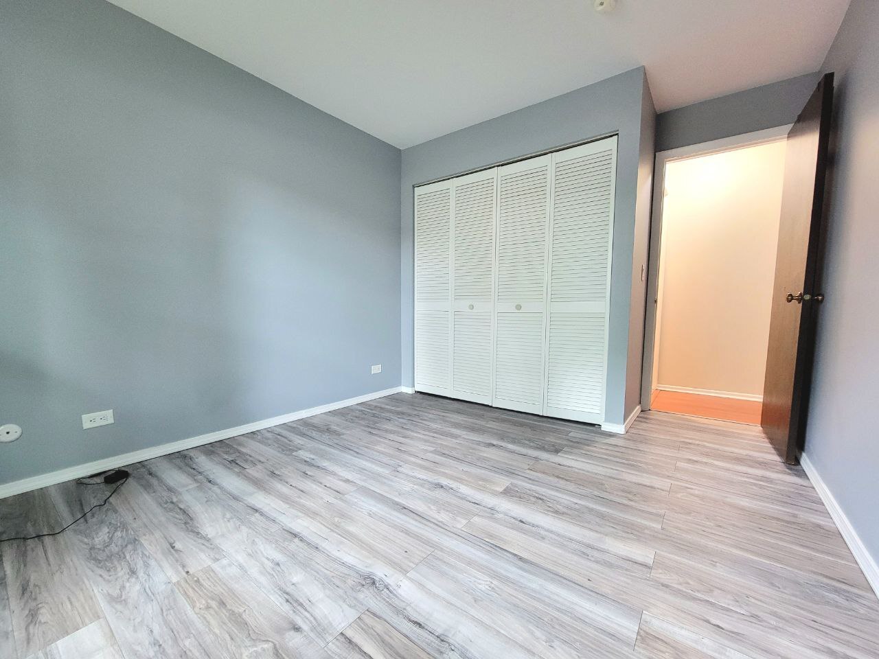 4730 Calvert Drive, Unit B1 Rolling Meadows, IL 60008 - Photo 18 of 23 a view of an empty room with wooden floor and a window