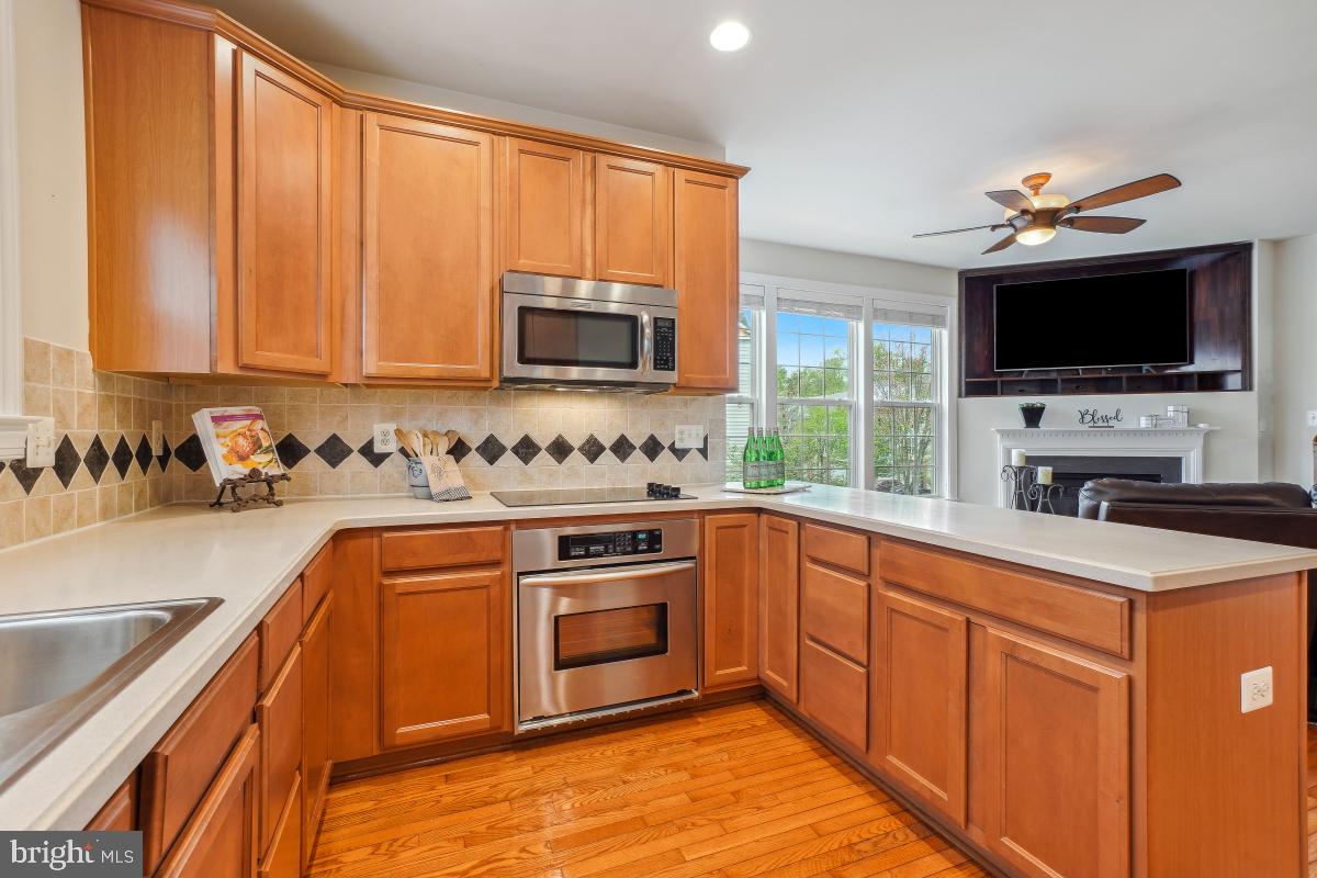 4091 River Forth Drive Fairfax, VA 22030 - Photo 11 of 32 a kitchen with stainless steel appliances granite countertop a stove top oven a sink dishwasher and a microwave oven with cabinets
