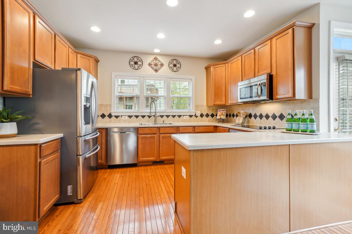 4091 River Forth Drive Fairfax, VA 22030 - Photo 12 of 32 a kitchen with stainless steel appliances granite countertop a refrigerator a sink dishwasher a stove with large countertops and wooden floor