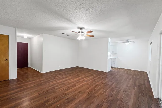 a view of a room with wooden floor and a ceiling fan