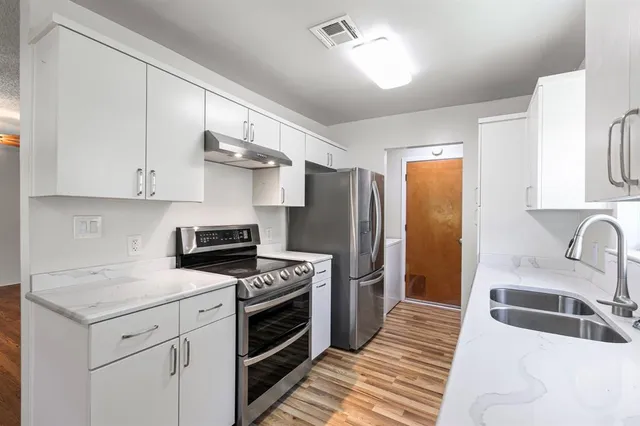a kitchen with stainless steel appliances granite countertop a sink stove and refrigerator