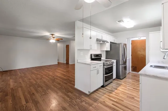 a kitchen with stainless steel appliances a refrigerator and a stove top oven