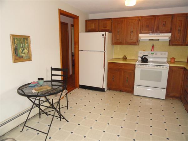 115 Leverett Road Amherst, MA 01002 - Photo 7 of 15 a kitchen with a table chairs and a refrigerator