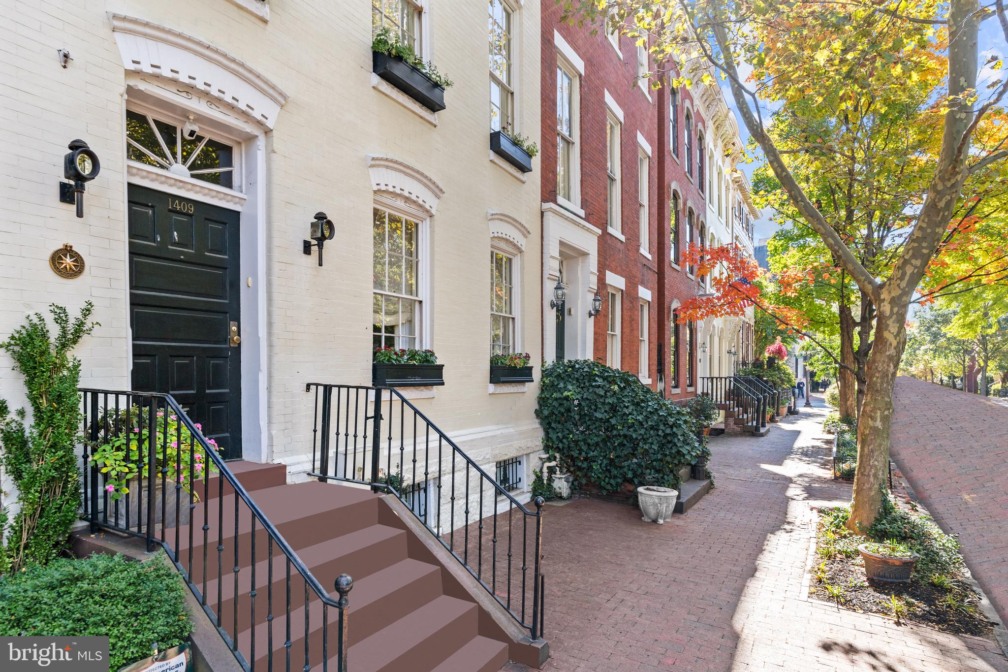 1409 31st Street Northwest Washington, DC 20007 - Photo 2 of 8 a view of a street with brick wall and potted plants