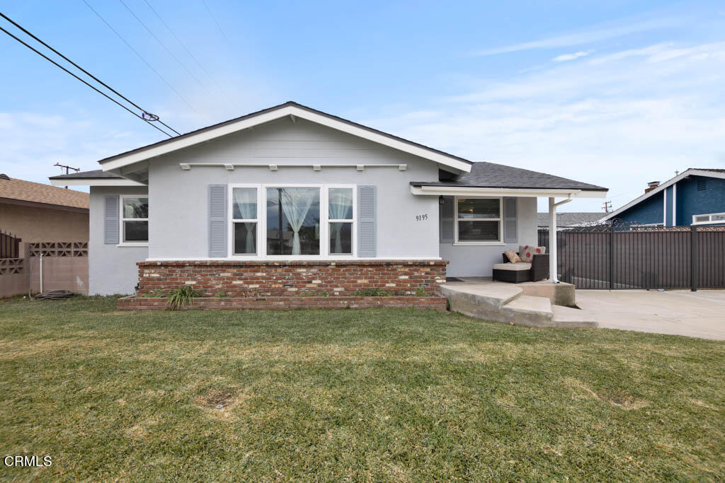 a view of a house with a yard and wooden fence