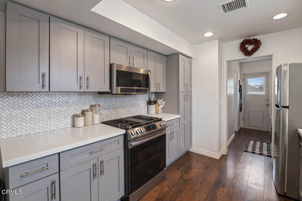 9195 Harvard Street Rancho Cucamonga, CA 91730 - Photo 19 of 37 a kitchen with granite countertop a stove a sink and a refrigerator